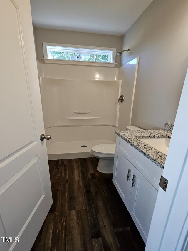 bathroom featuring a wealth of natural light, vanity, wood-type flooring, and toilet