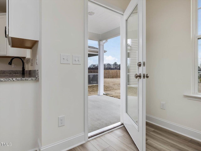 entryway with light wood-type flooring, french doors, and sink