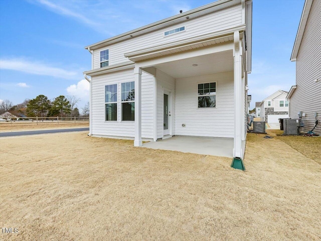 rear view of house with central AC unit and a patio