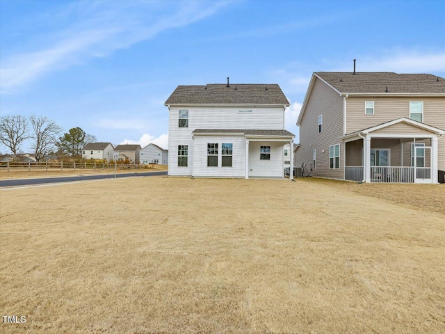 rear view of property featuring a lawn