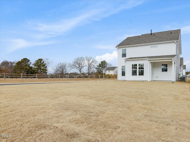 rear view of house featuring central AC unit and a rural view