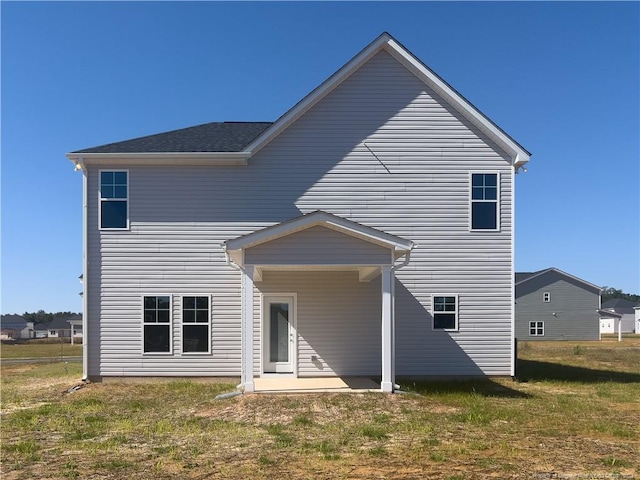 rear view of property featuring a lawn