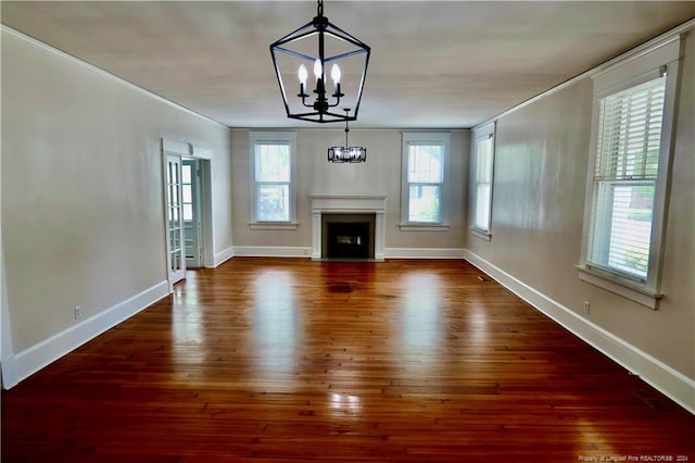 unfurnished living room with a notable chandelier and dark hardwood / wood-style flooring