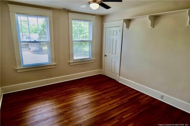 spare room with dark hardwood / wood-style flooring and ceiling fan