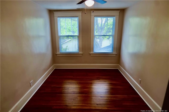 unfurnished room with ceiling fan and dark wood-type flooring