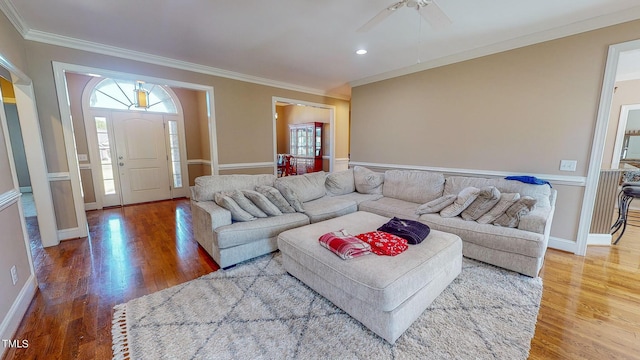 living room with crown molding, ceiling fan, and wood-type flooring