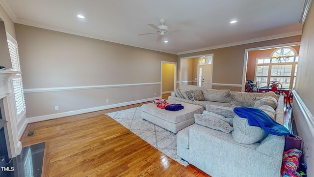 living room featuring wood-type flooring, ceiling fan, and crown molding