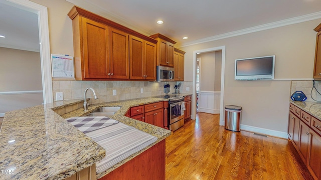 kitchen featuring sink, light stone counters, ornamental molding, and stainless steel appliances