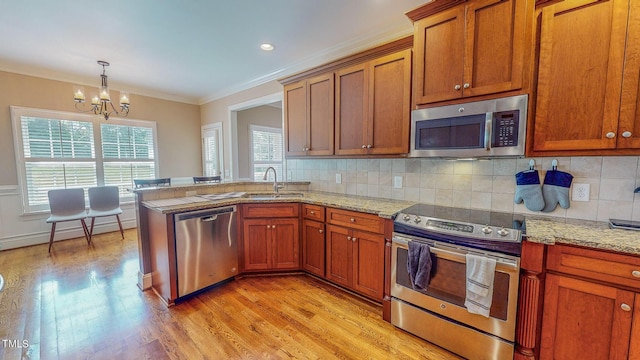 kitchen with decorative backsplash, sink, a notable chandelier, and appliances with stainless steel finishes