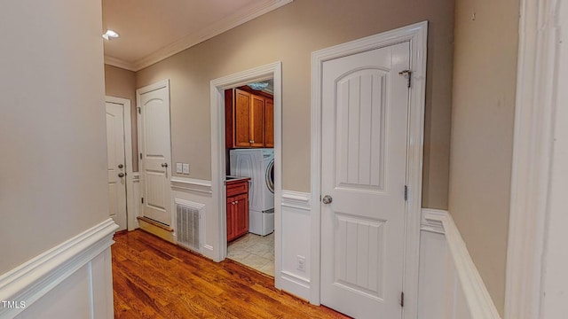 hallway featuring hardwood / wood-style floors, washer / dryer, and crown molding