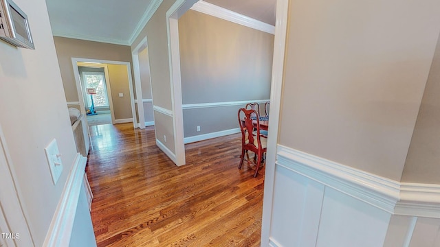 hall with wood-type flooring and ornamental molding