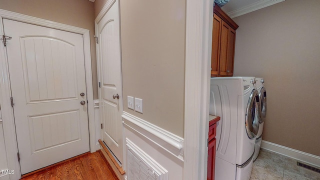 laundry room featuring cabinets, independent washer and dryer, and crown molding