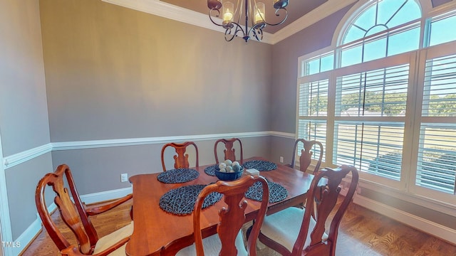 dining area featuring a wealth of natural light, ornamental molding, wood-type flooring, and an inviting chandelier