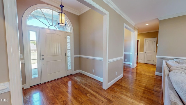 entryway with ornamental molding and light hardwood / wood-style flooring