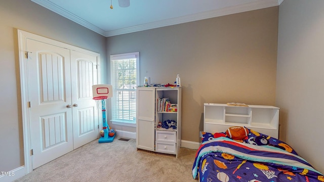 bedroom with ornamental molding, a closet, ceiling fan, and light colored carpet