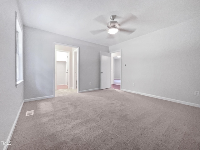 unfurnished bedroom with connected bathroom, light carpet, and ceiling fan