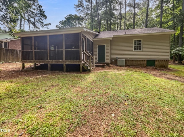 back of property featuring a sunroom and a lawn