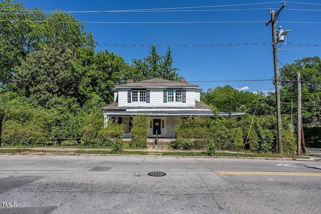 view of front of house featuring covered porch and a chimney