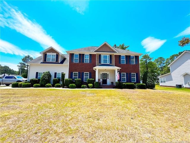 colonial home featuring a front lawn