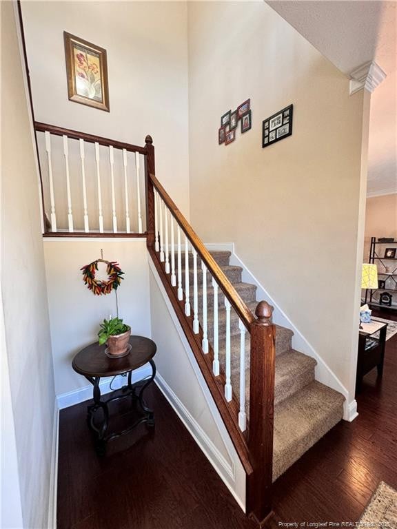 stairway with hardwood / wood-style floors and decorative columns