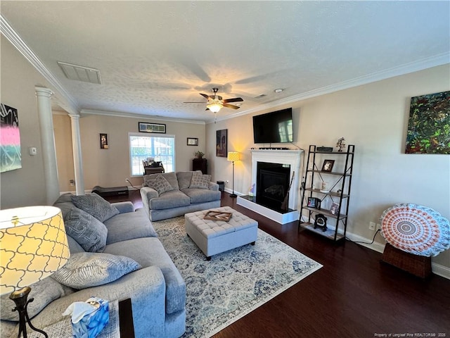 living room with decorative columns, crown molding, hardwood / wood-style floors, and ceiling fan