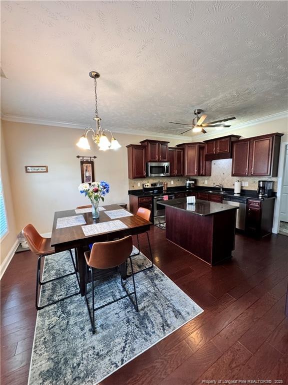 dining room with ceiling fan with notable chandelier, sink, crown molding, dark wood-type flooring, and a textured ceiling