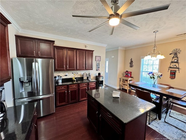 kitchen with ornamental molding, stainless steel fridge with ice dispenser, and a textured ceiling