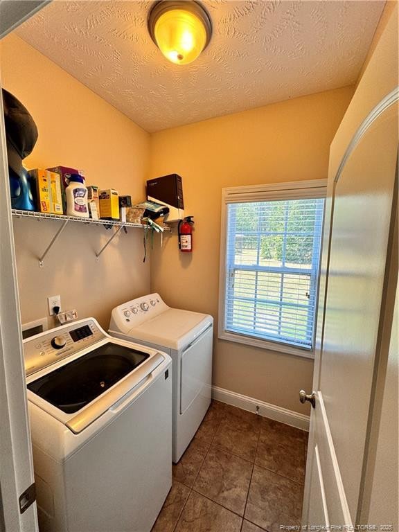 laundry area featuring dark tile patterned flooring, independent washer and dryer, and a textured ceiling