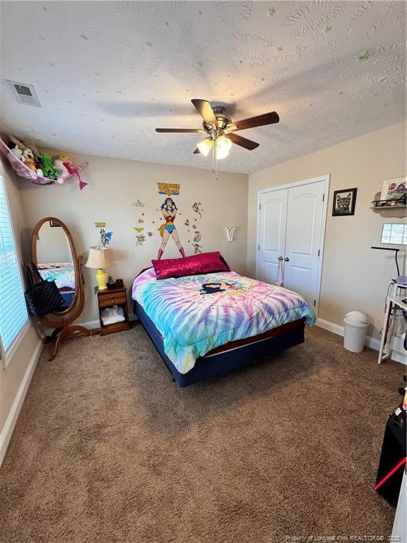 bedroom featuring carpet floors, a textured ceiling, ceiling fan, and a closet