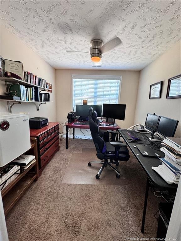 home office with ceiling fan, a textured ceiling, and carpet flooring