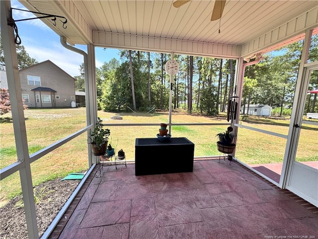 unfurnished sunroom featuring ceiling fan and a healthy amount of sunlight