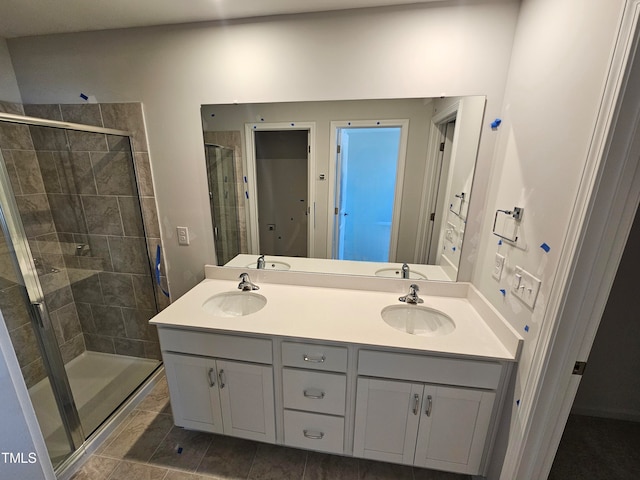 bathroom featuring a shower with door and vanity