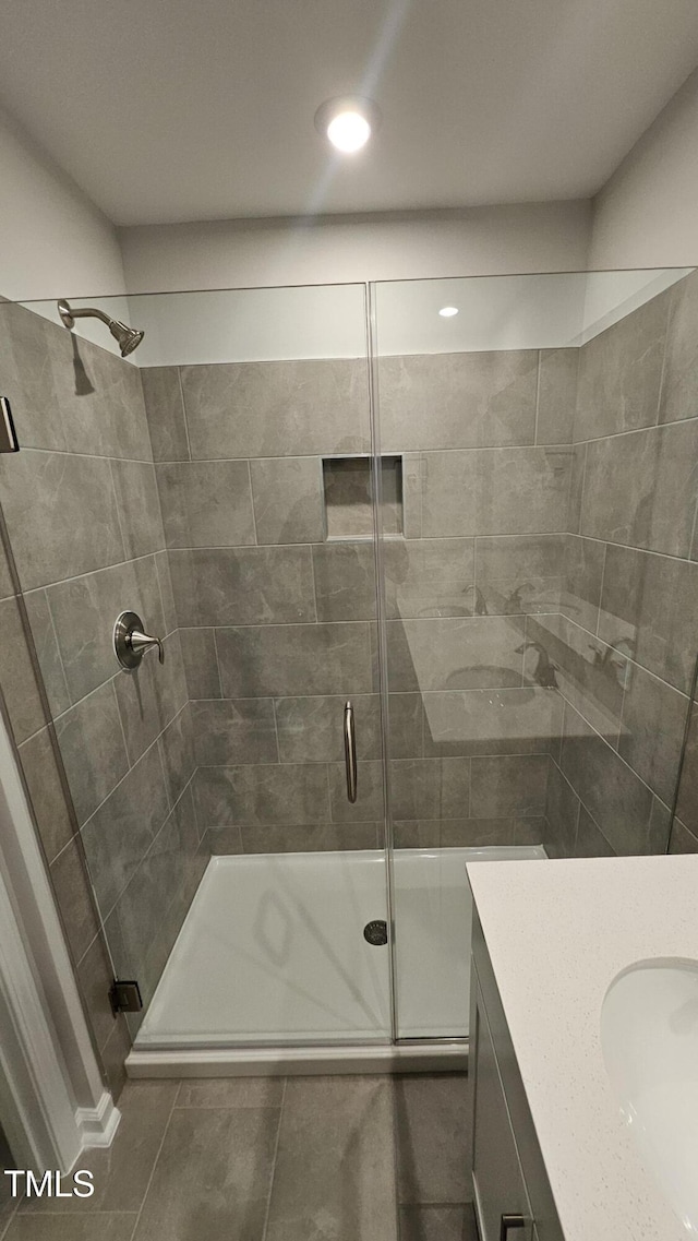 bathroom with tile patterned flooring, vanity, and a shower with shower door