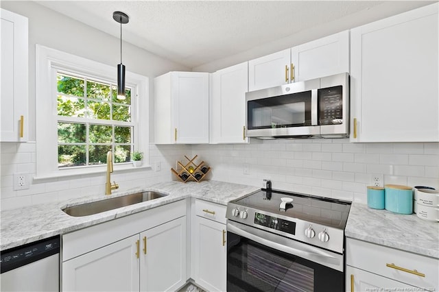 kitchen with white cabinets, appliances with stainless steel finishes, and tasteful backsplash