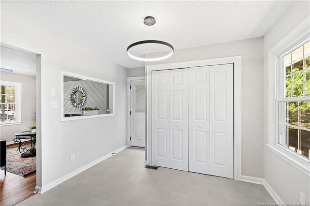 unfurnished bedroom featuring multiple windows, a closet, and a textured ceiling