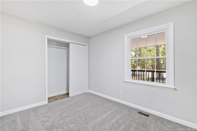 unfurnished bedroom featuring carpet floors and a closet