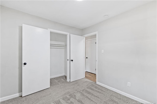 unfurnished bedroom featuring light colored carpet and a closet