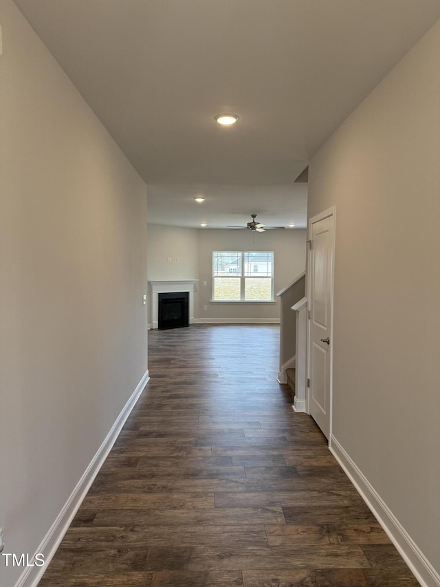 unfurnished living room featuring a fireplace, recessed lighting, dark wood-type flooring, ceiling fan, and baseboards