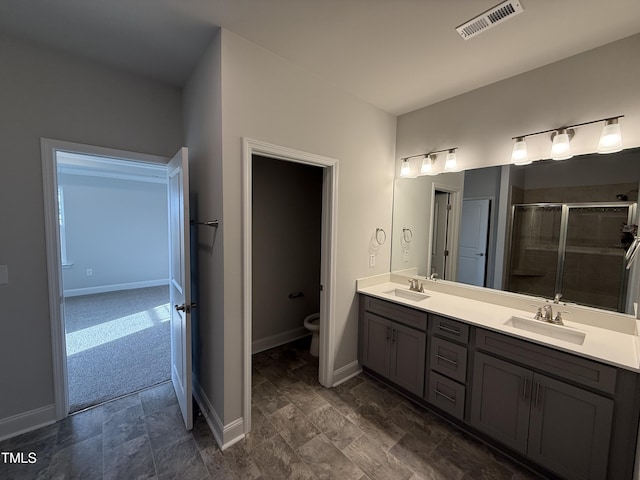 bathroom featuring double vanity, baseboards, visible vents, and a sink