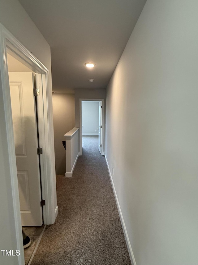 hall featuring carpet floors and baseboards