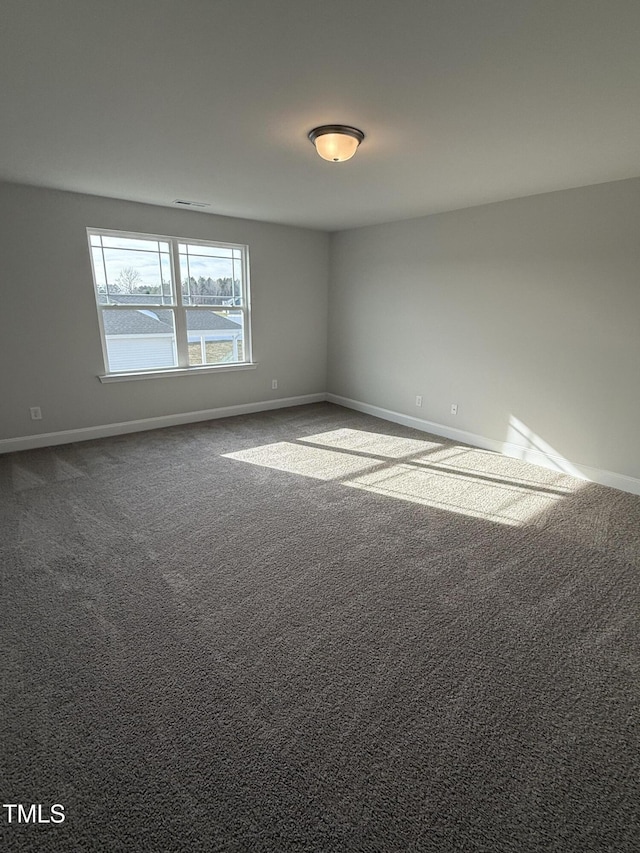 unfurnished room featuring carpet floors and baseboards