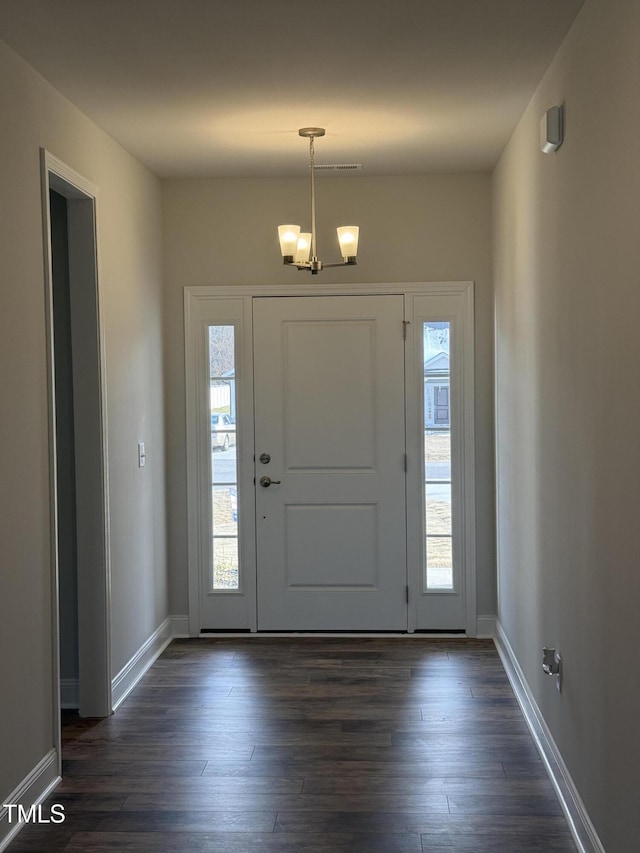 entryway featuring a chandelier, dark wood-type flooring, and a wealth of natural light