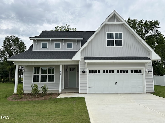 view of front of home featuring a garage, a front yard, and covered porch