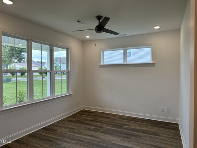 spare room featuring plenty of natural light, dark hardwood / wood-style floors, and ceiling fan