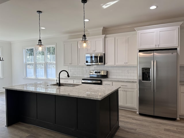 kitchen featuring pendant lighting, sink, a kitchen island with sink, stainless steel appliances, and white cabinets