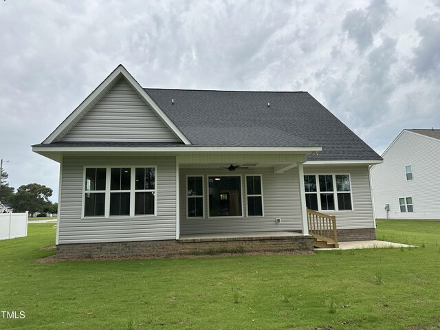 back of property with a lawn, ceiling fan, and a patio area