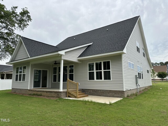 back of property with ceiling fan, a patio, and a lawn