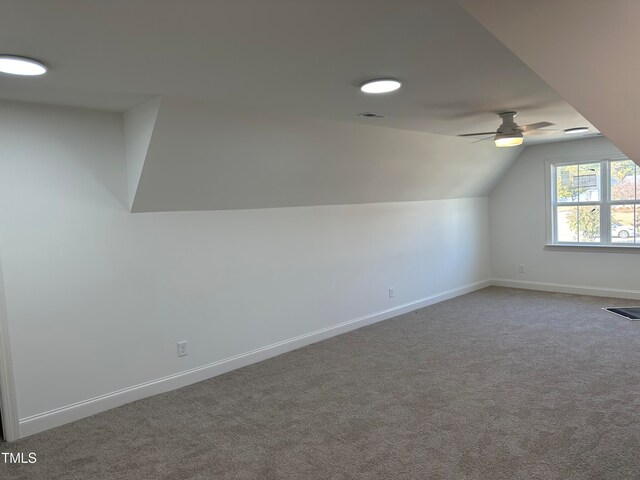 additional living space featuring vaulted ceiling, carpet, and ceiling fan