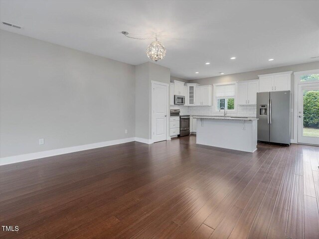 kitchen with a kitchen island, dark hardwood / wood-style flooring, white cabinetry, sink, and stainless steel appliances