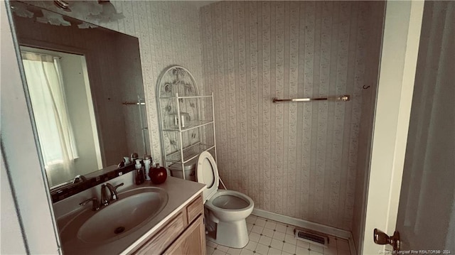 bathroom with toilet, tile patterned floors, and vanity